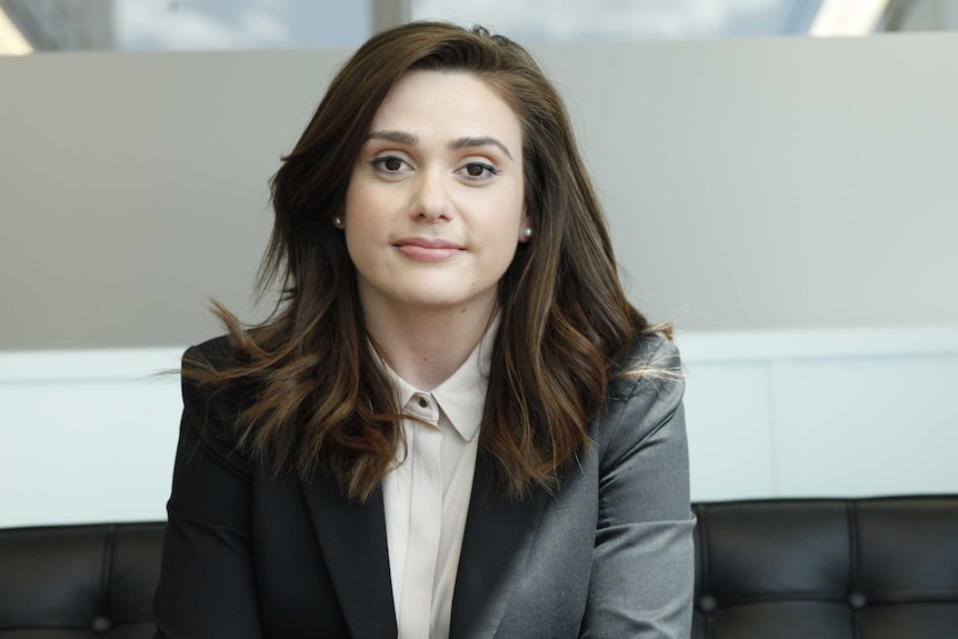 Profile shot of CoreLogic's head of research Australia, Eliza Owen sitting in an office wearing a suit.