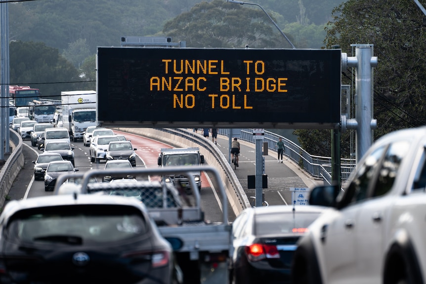 Image shows congestion and traffic delays. You can see cars, grey road on a gloomy day.