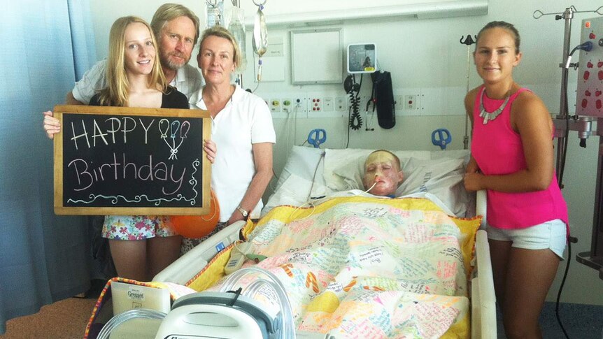 The Turkingtons with Paris in hospital holding a happy birthday sign
