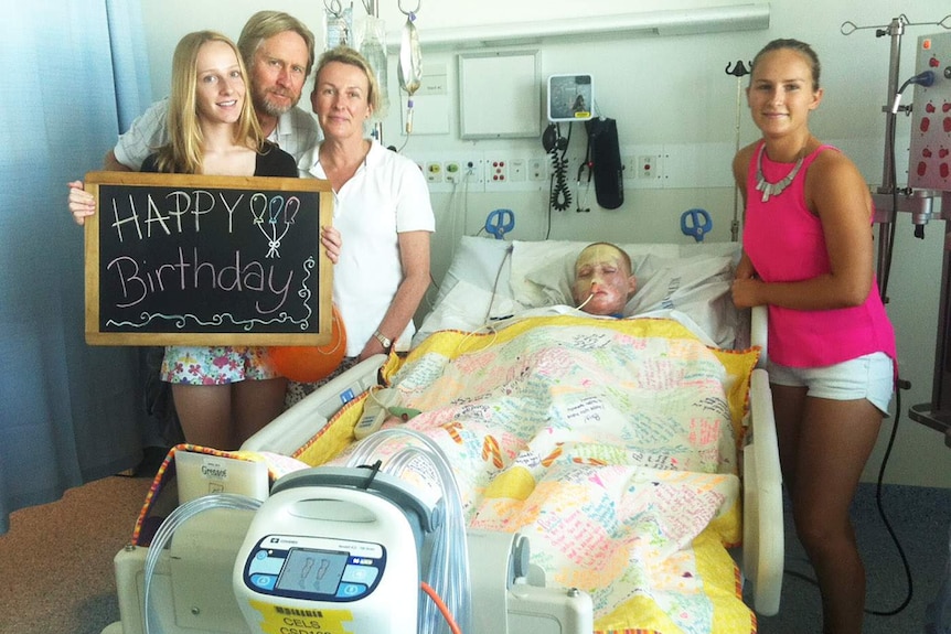 The Turkingtons with Paris in hospital holding a happy birthday sign