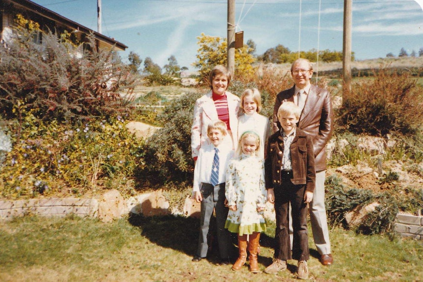 John and Trish Hagan pose with their kids in a family photograph.