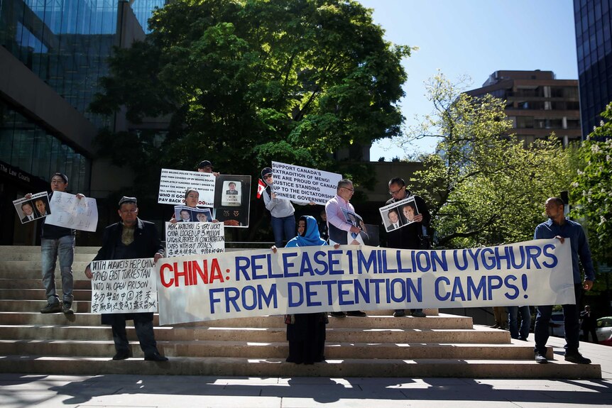 Uyghurs protest with a sign that reads "China: release 1 million Uyghurs from detention camps".