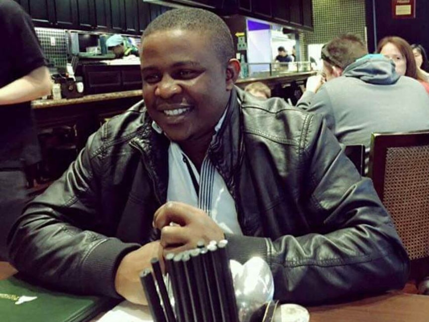 Nigerian national Jackson Igwebuike sits in a cafe.