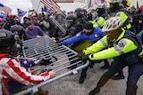 Rioters try to break through a police barrier at the Capitol