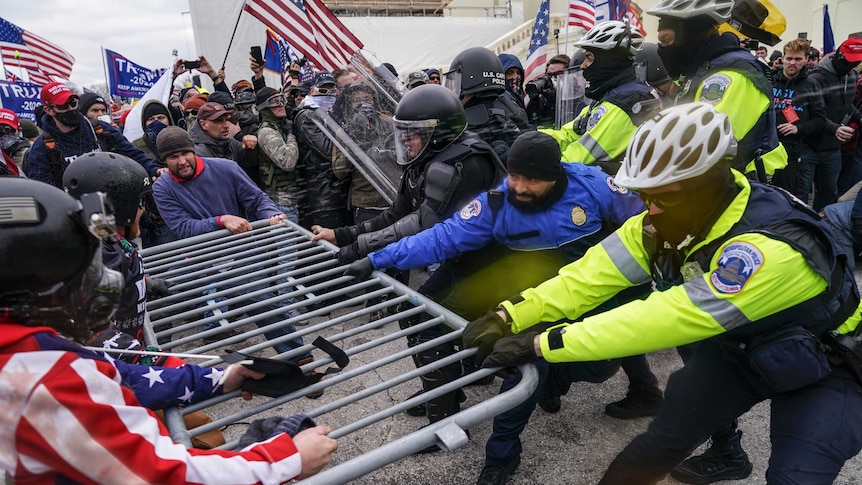 Rioters try to break through a police barrier at the Capitol