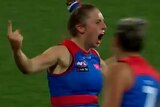 Jess Fitzgerald yells and puts her finger up in celebration as teammates approach her