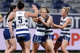 Kate Surman is congratulated by her Geelong teammates after kicking a goal in round one of AFLW 2023