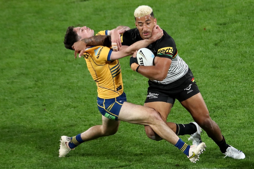 Viliame Kikau palms off Mitchell Moses as he tries to tackle him