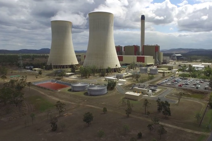 Two large cooling towers in the foreground and the Stanwell power station in the background, surrounded by low-lying mountains.
