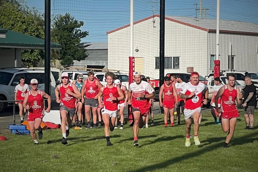 Football players running on an oval.