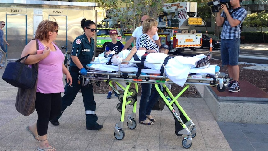 Paramedics take victims of the escalator accident at the Esplanade train station to hospital.