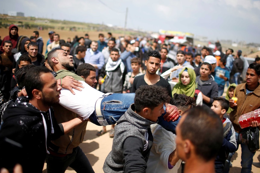 An injured man is carried by severall men at the site of the clashes near gaza