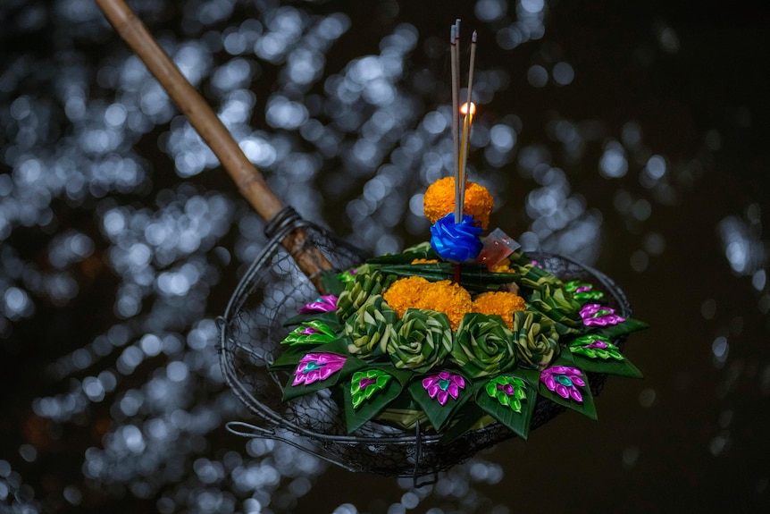 A colourful krathong is scooped out of the Chao Phraya river in Bangkok.
