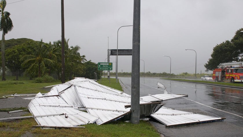 Cyclone debris litters a road at the entrance to Mackay's business district.
