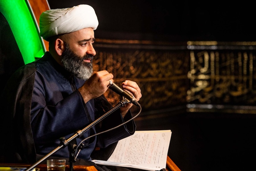 A photo of Sheikh Al-Ameli wearing his white turban, during one of his lectures.