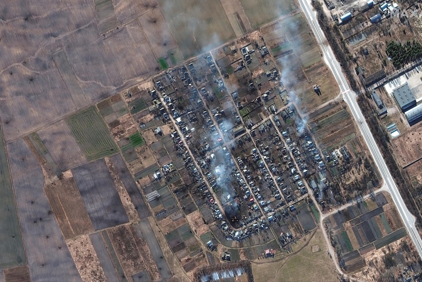 Satellite photo showing smoke rising from residential homes.