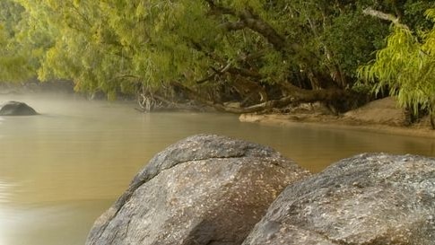 Water flows past rocks on the Archer River.