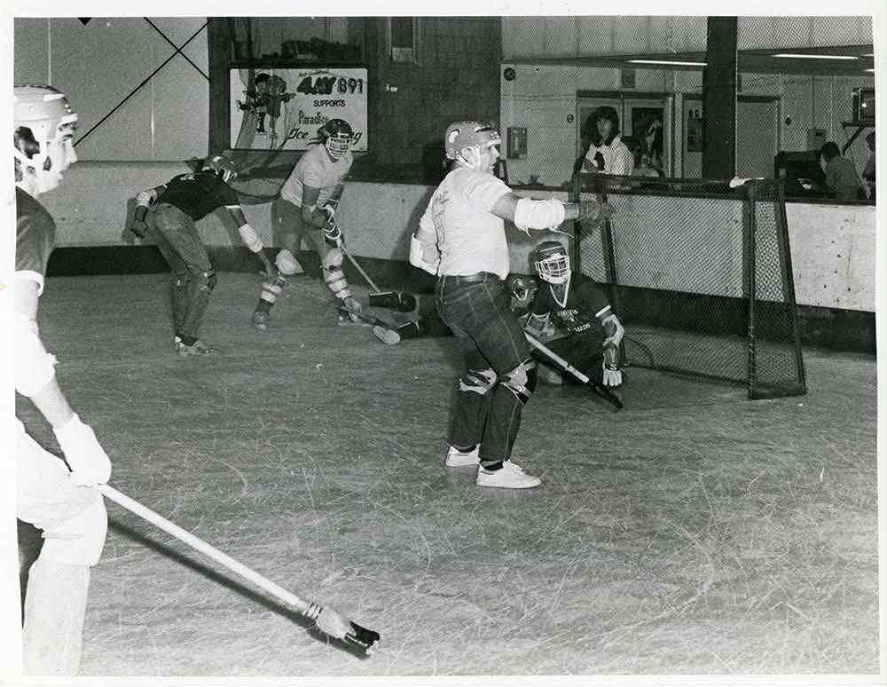 Uma fotografia em preto e branco de atletas com armaduras de hóquei.