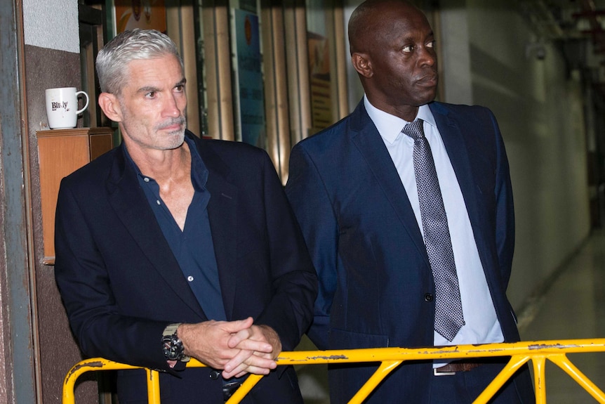 Former Socceroo Craig Foster (left) waits to meet Hakeem AlAraibi as he arrives at court.