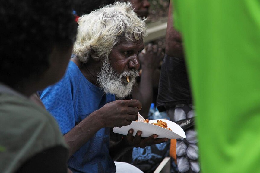 A photo of an Indigenous man eating a plate of food.