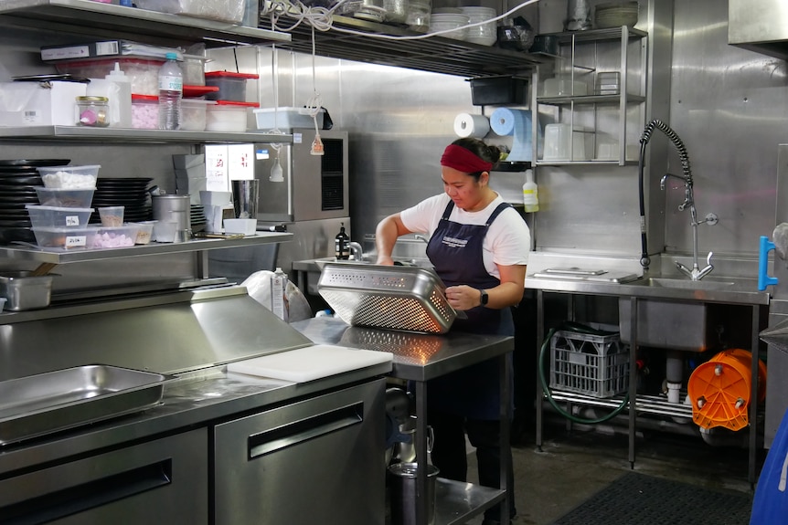 A woman works in an industrial kitchen