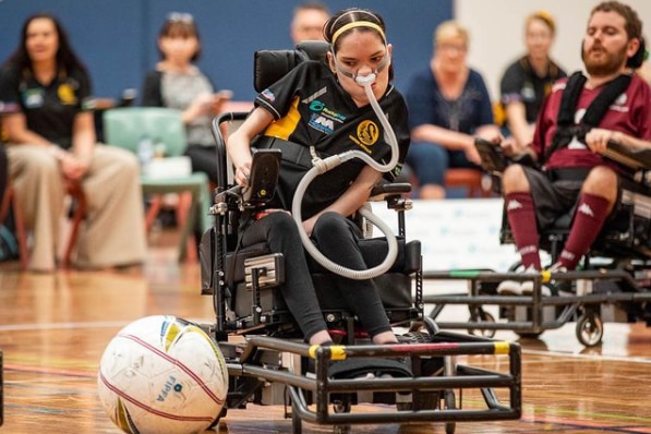 Powerchair athlete hitting the ball during a match.