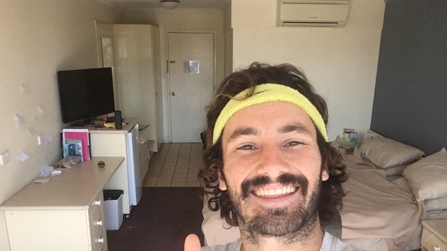 Selfie of man in sweatband doing thumbs up to camera