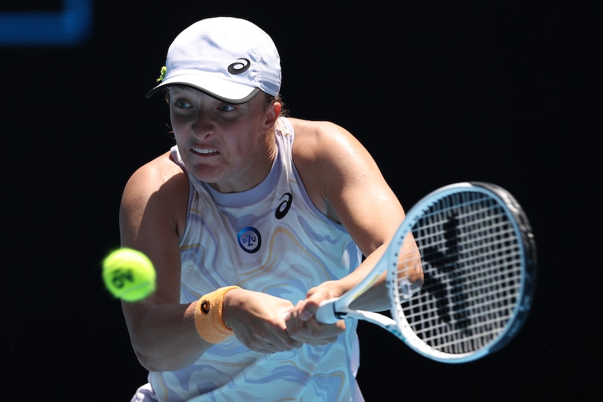 A Polish female tennis player hits a backhand at the Australian Open.