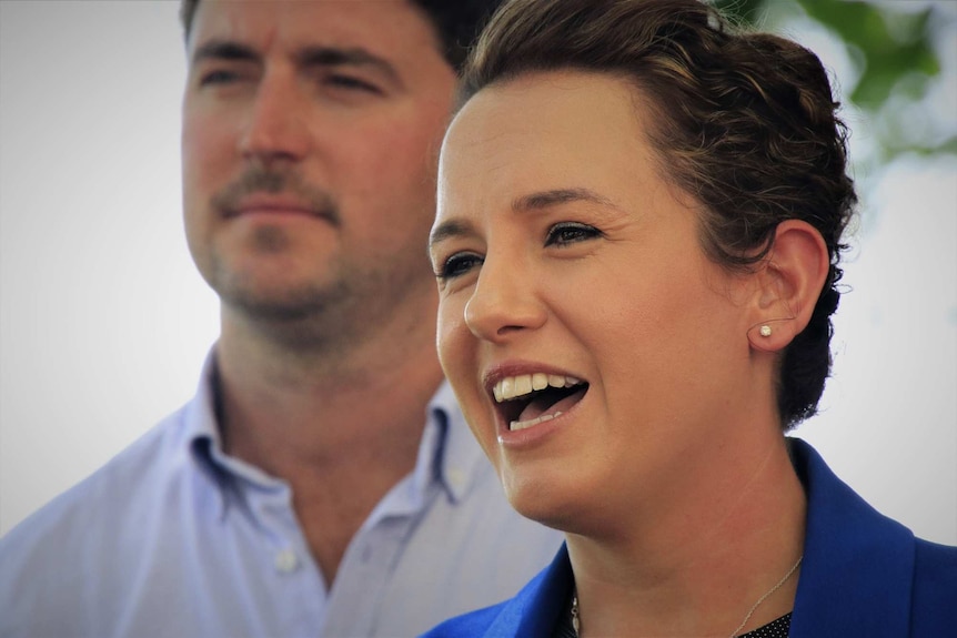 Lia Finocchiaro talks to media with Josh Burgoyne standing behind her.