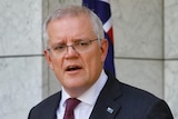 Scott Morrison stands before the entrance to parliament in the prime minister's courtyard, behind a lectern.