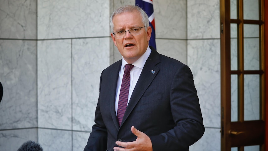 Scott Morrison stands before the entrance to parliament in the prime minister's courtyard, behind a lectern.
