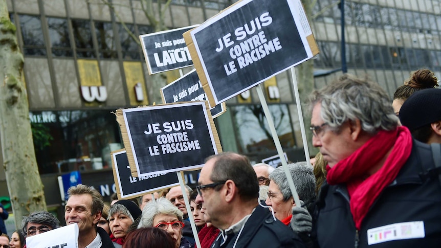 People hold signs in Charlie Hebdo rally