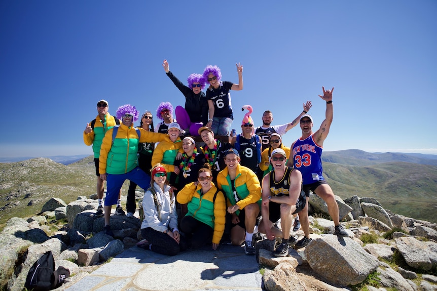 a group of people cheering at the top of a mountain