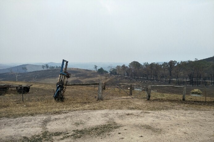 A few of rolling hills across Buchan East, blackened and burnt under a smoke-filled sky.