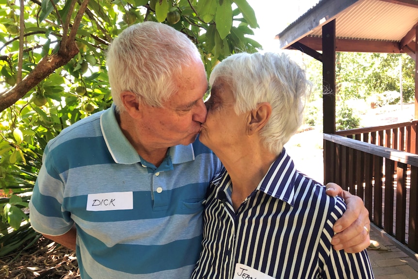 Man and woman in their 70s kiss