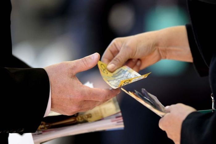 Woman hands over cash to man.