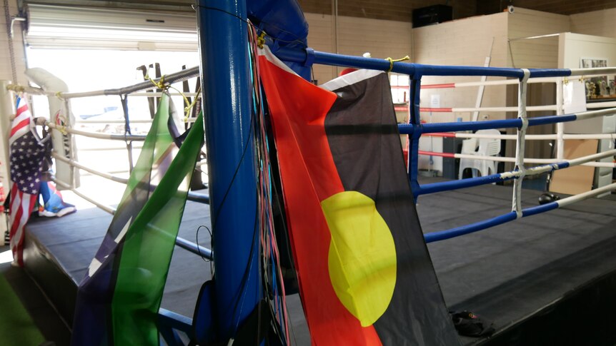 An empty boxing ring, decorated with the Aboriginal and Torres Strait Islander flags
