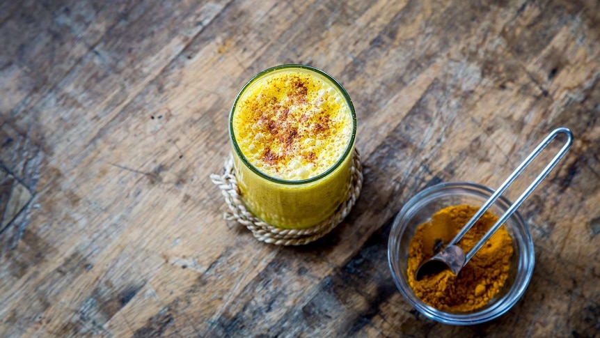 Turmeric latte in a glass for a story about the benefits and how to use turmeric