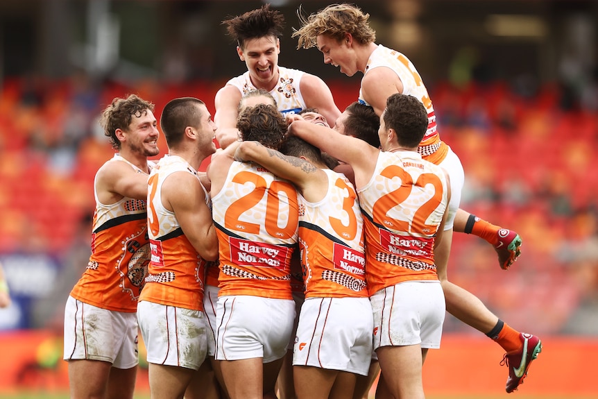 GWS players leap in a huddle