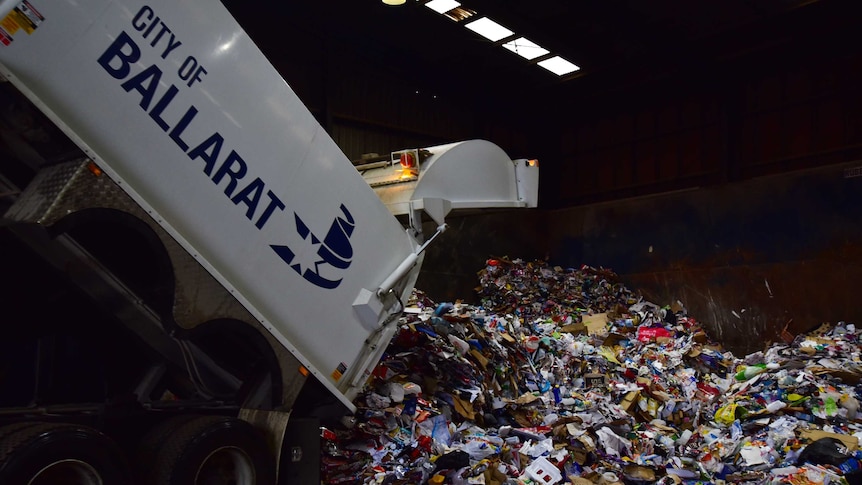 dump truck dumping recyclable materials at warehouse