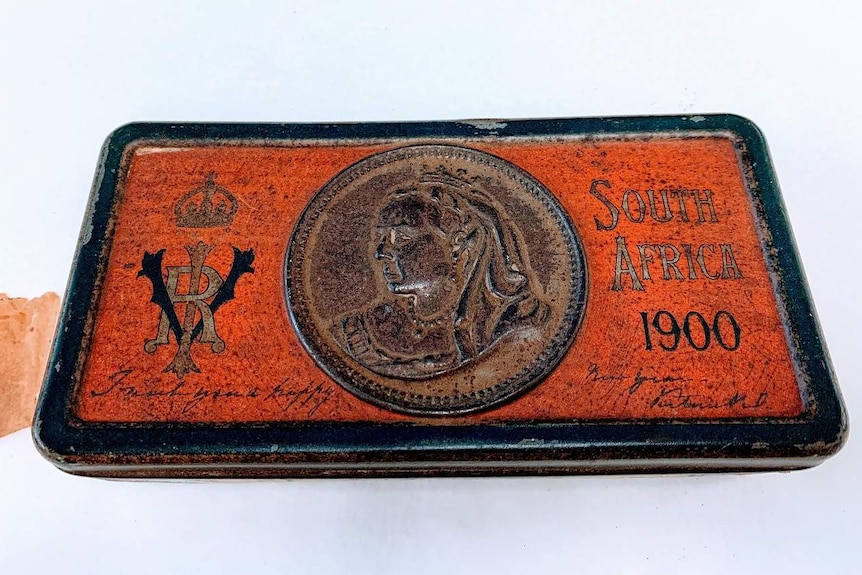 A rusted tin with an image of Queen Victoria.