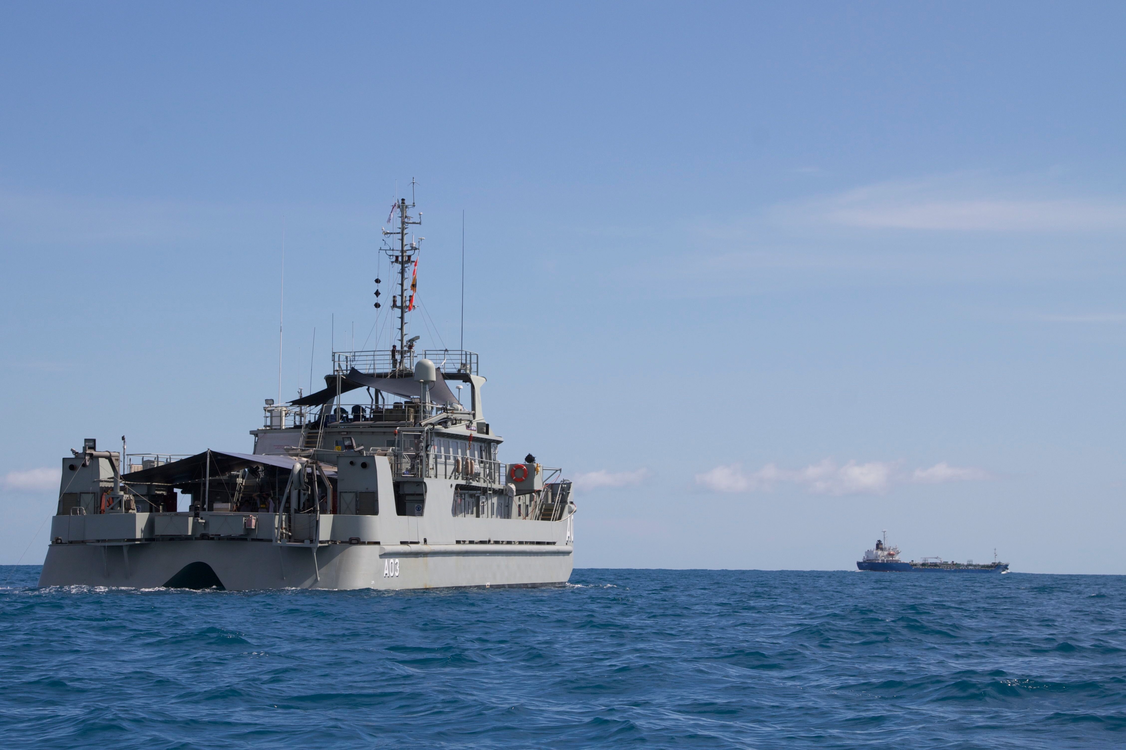 Low shot of catamaran-style naval ship at sea.