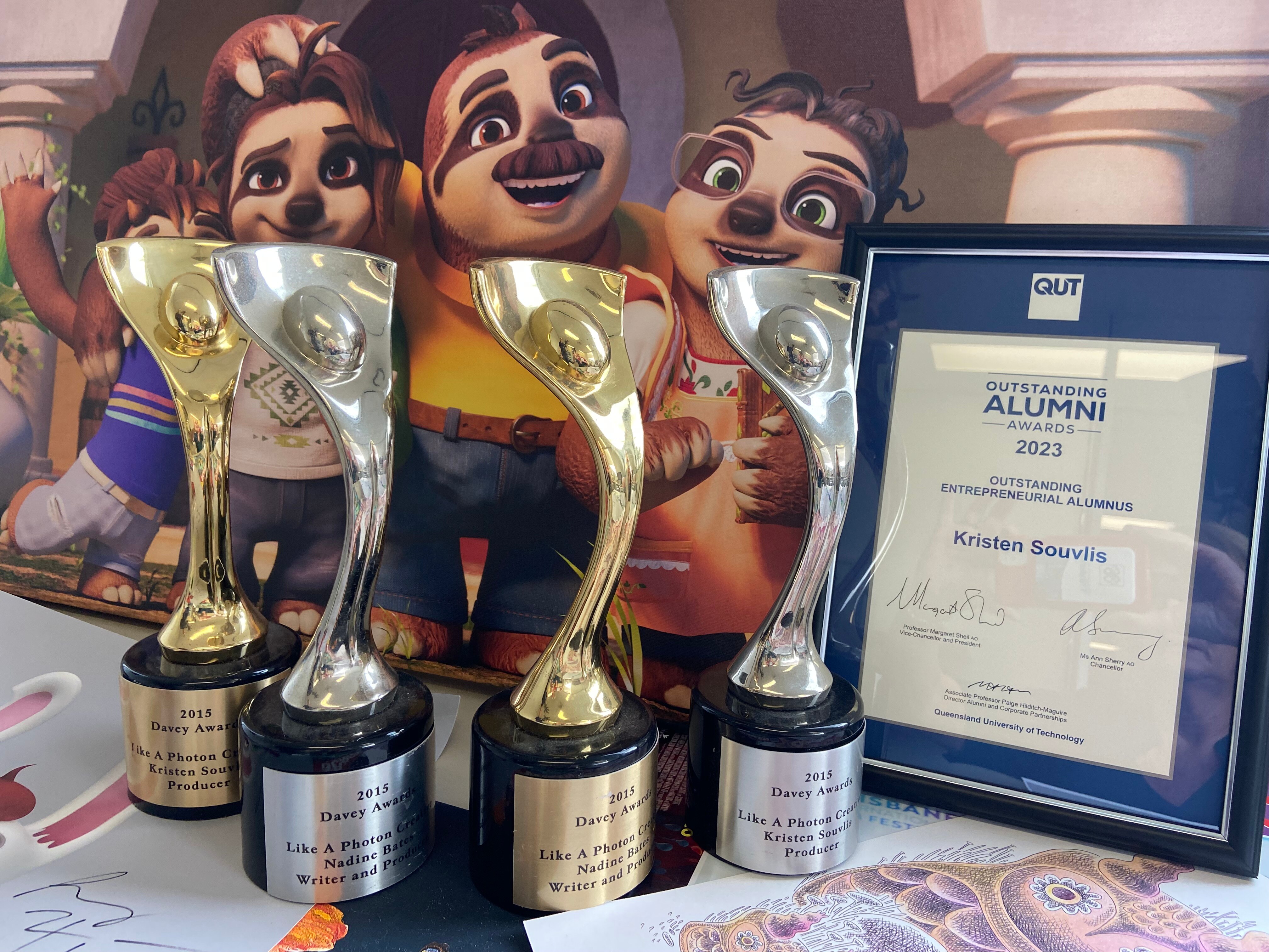 A group of awards, sitting in front of a poster for an animated kids' movie.