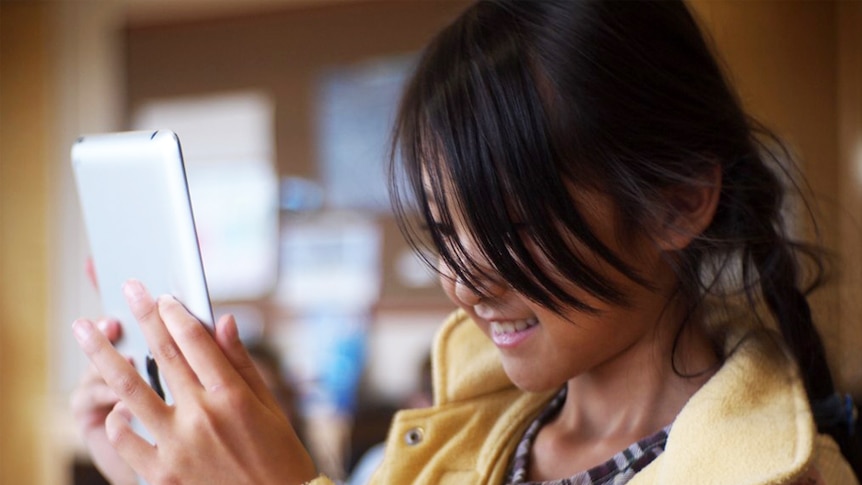 A young girl uses an iPad.