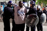 Riot police detain a man in Birmingham
