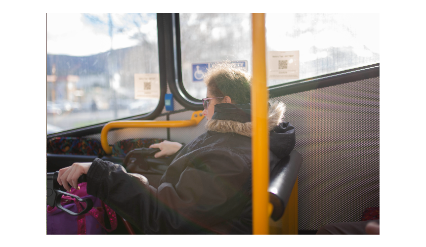 A woman with a walking frame on a bus.