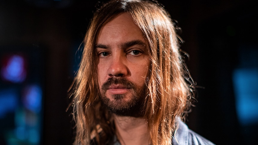 Kevin Parker of Australian band Tame Impala looks at the camera in a close-up portrait.