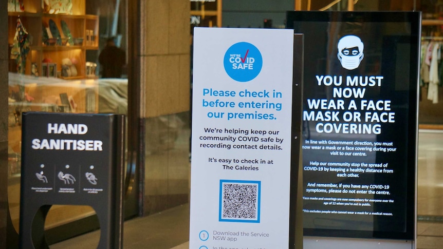 A QR code and a mask sign at a Sydney shopping centre.