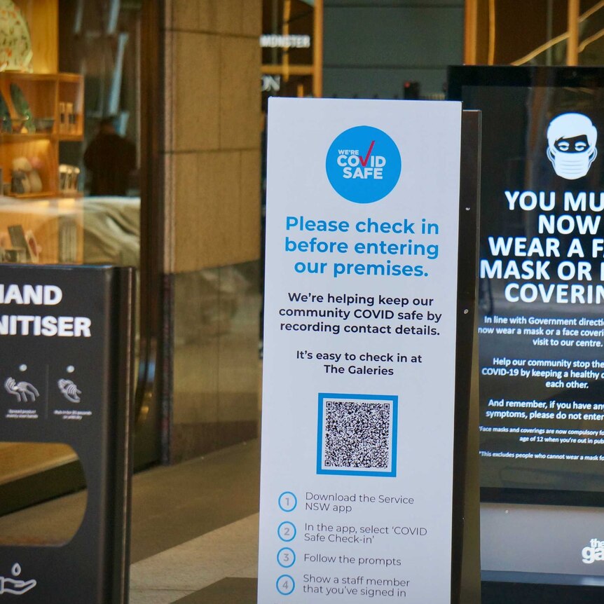 A QR code and a mask sign at a Sydney shopping centre.