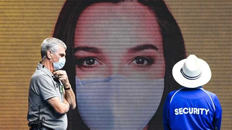 An image of a woman wearing a mask in a mural with two men next to it wearing masks.